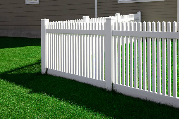 corner white fence and grass lawn near the house