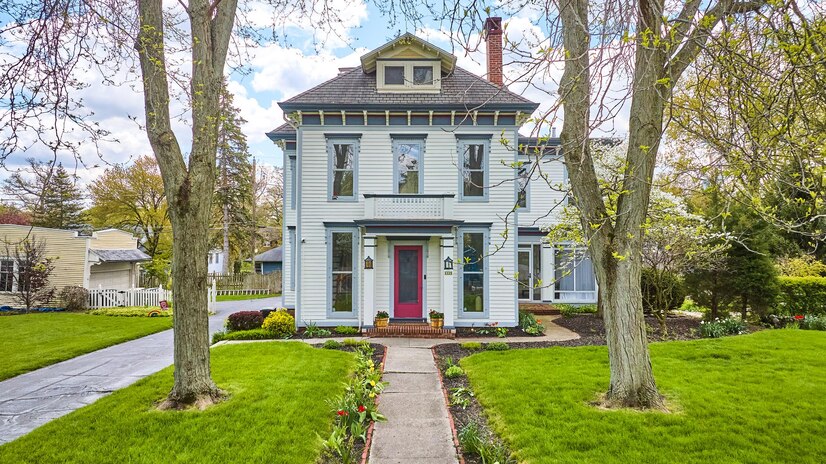 magenta-front-door-white-house-blue-window-frames-two-big-trees-lining-front-sidewalk-real-estate_501731-8338