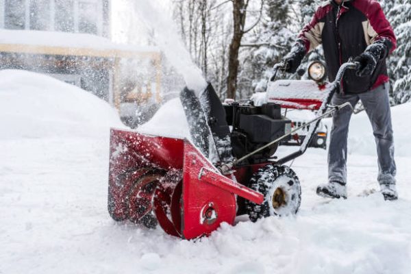 Senior Man Using SnowBlower After a Snowstorm, Quebec, Canada Senior Man Using SnowBlower After a Snowstorm, Quebec, Canada