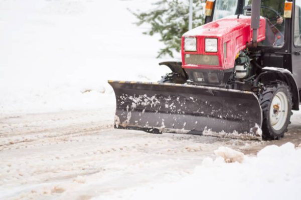 low_quality-fZFz4cKhtX Red tractor cleaning the streets of large amounts of snow in city after snowfall. Winter time concept